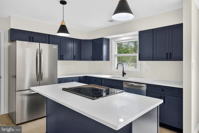 a kitchen that has a sink a refrigerator and cabinets