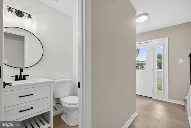a bathroom with a toilet a sink and mirror