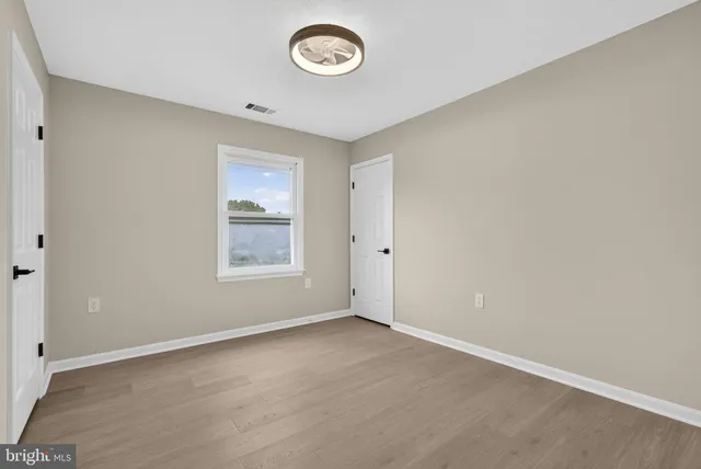 a view of an empty room with wooden floor