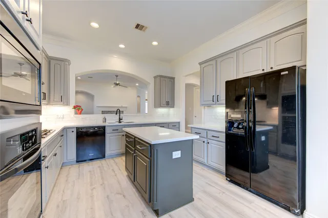 a kitchen with stainless steel appliances granite countertop a stove top oven a sink and dishwasher