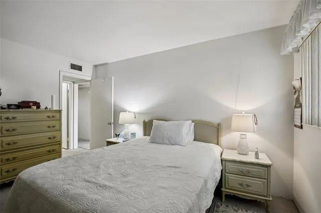 a bedroom with a bed and a flat tv screen on the dresser