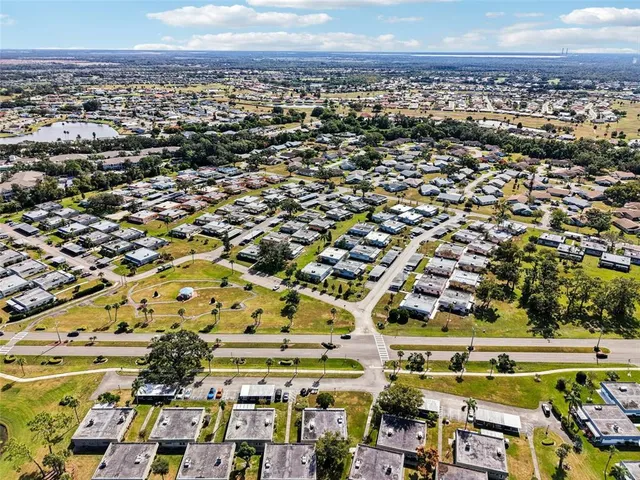 an aerial view of a residential houses with outdoor space and trees