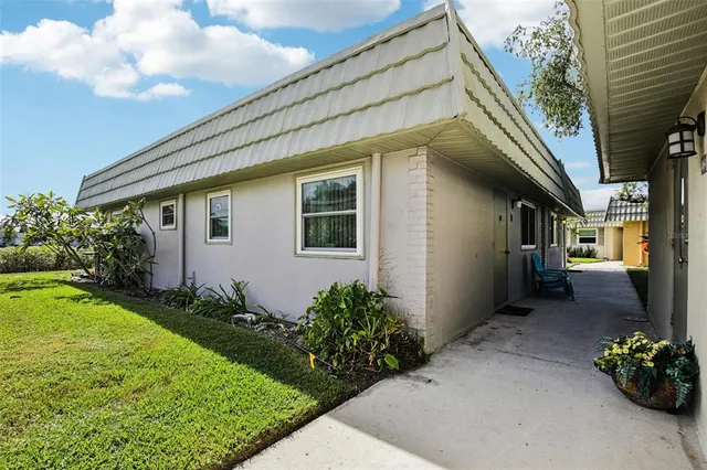 a front view of house with a yard and potted plants