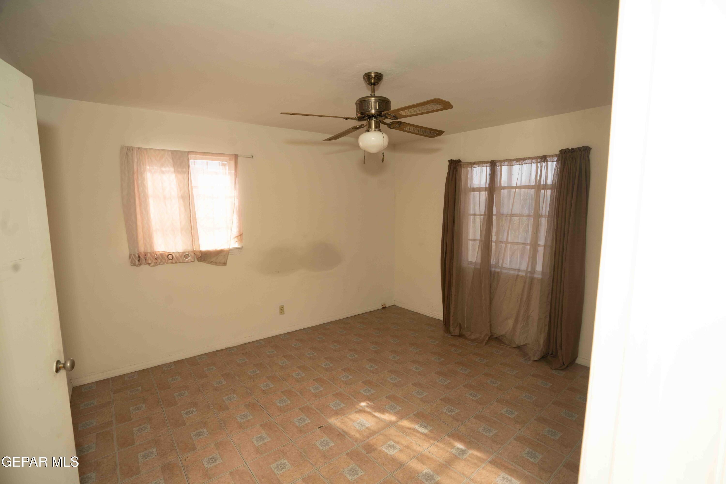 140 Teakwood Road El Paso, TX 79915 - Photo 8 of 16 an empty room with windows and fan