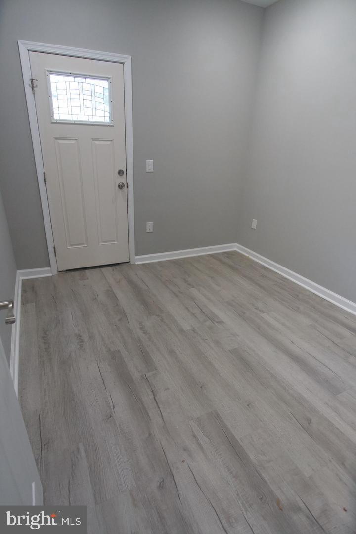 630 Brooklyn Street, Unit 1 Philadelphia, PA 19104 - Photo 3 of 7 an empty room with wooden floor and windows