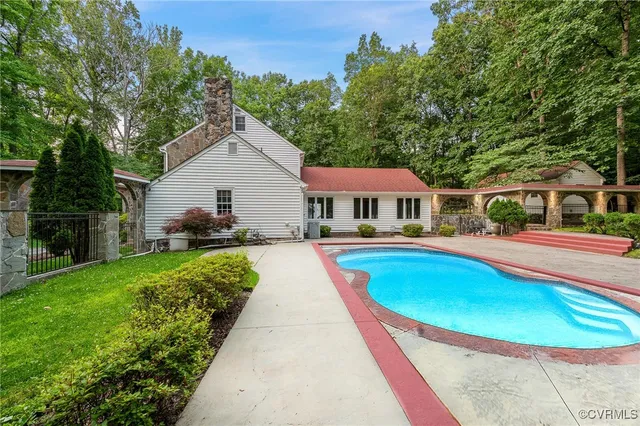 a view of house with swimming pool outdoor seating