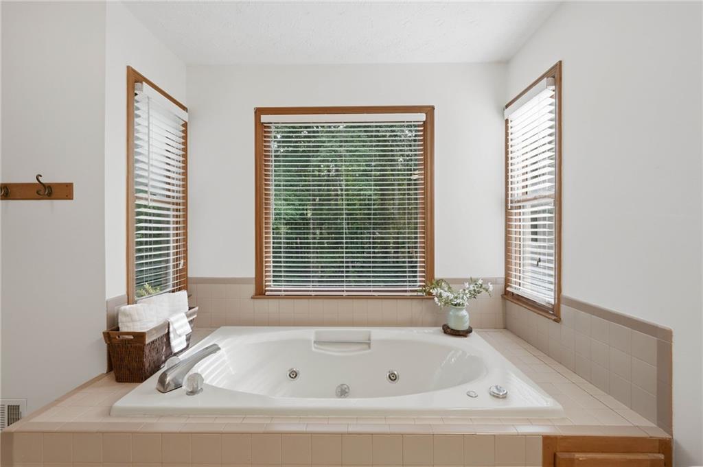 4891 Bill Cheek Road Auburn, GA 30011 - Photo 38 of 99 a bathroom with a bathtub next to a window