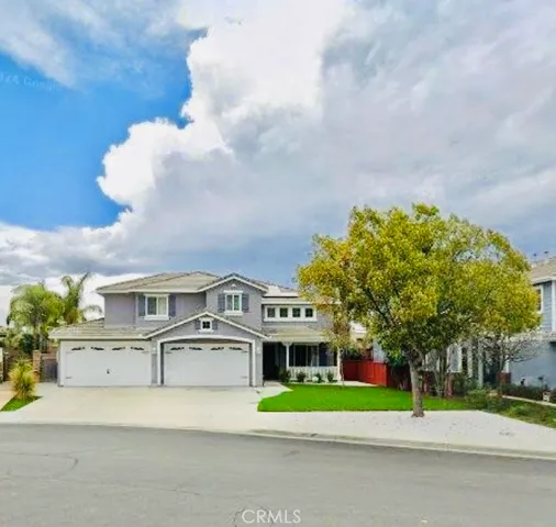 a white building with a big yard and large trees