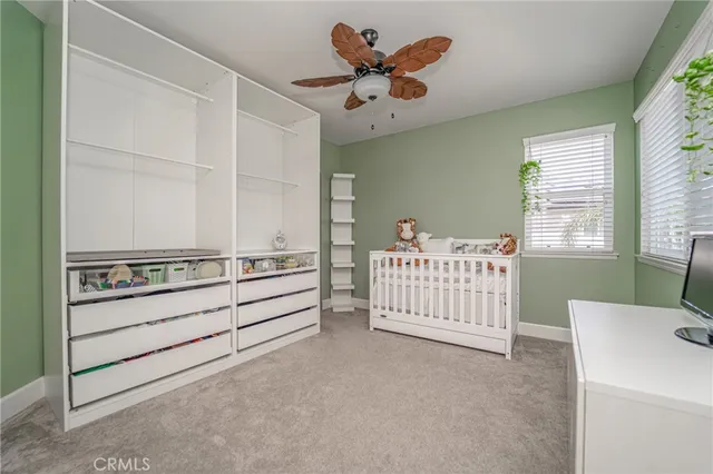 a view of a bedroom with furniture window and a ceiling fan