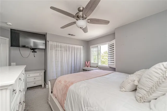 a bedroom with a bed a window and a chandelier