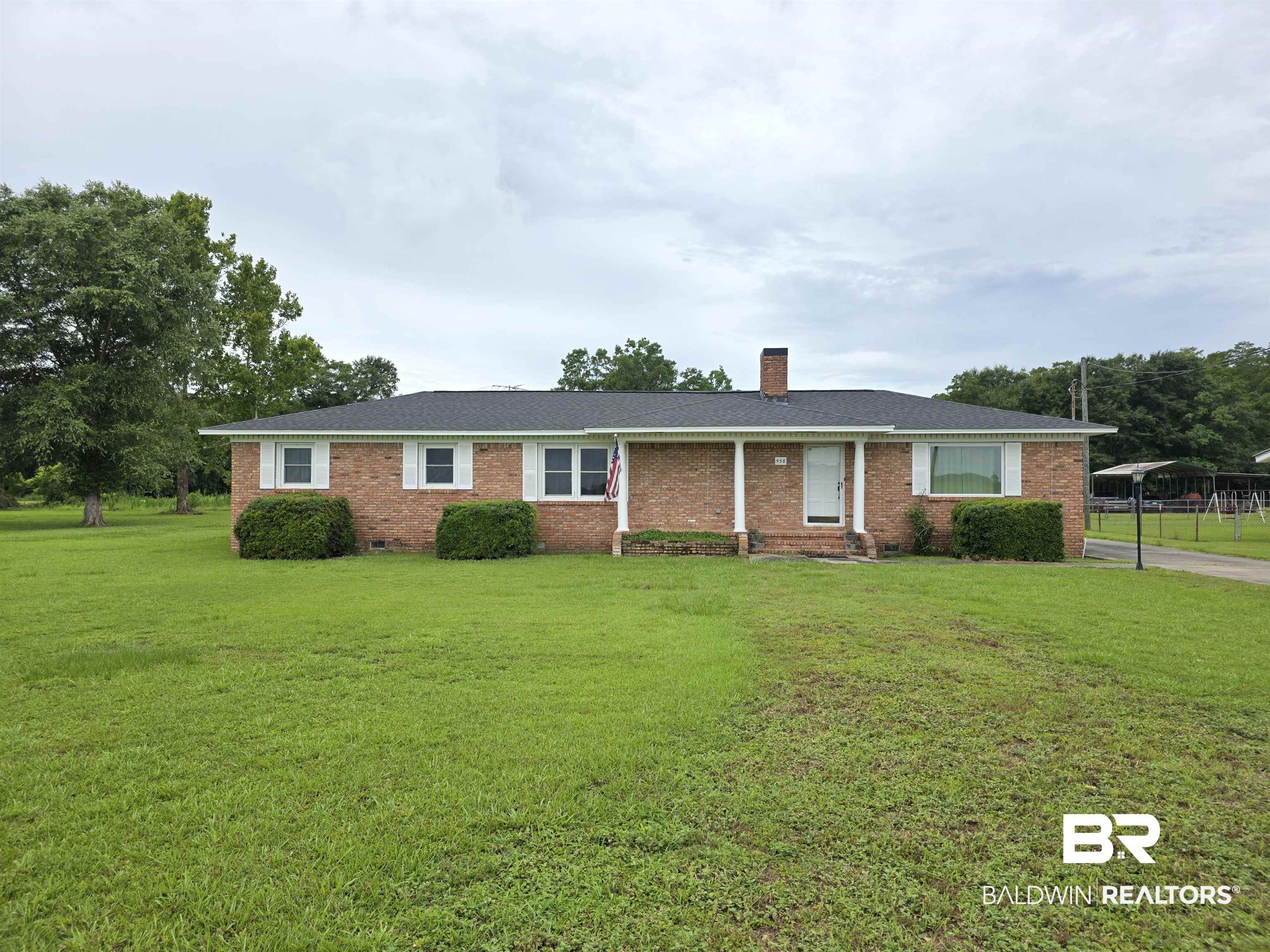 558 Stanton Road Atmore, AL 36502 - Photo 1 of 29 Brick exterior residence with a dark shingle roof and a covered front porch featuring white support columns