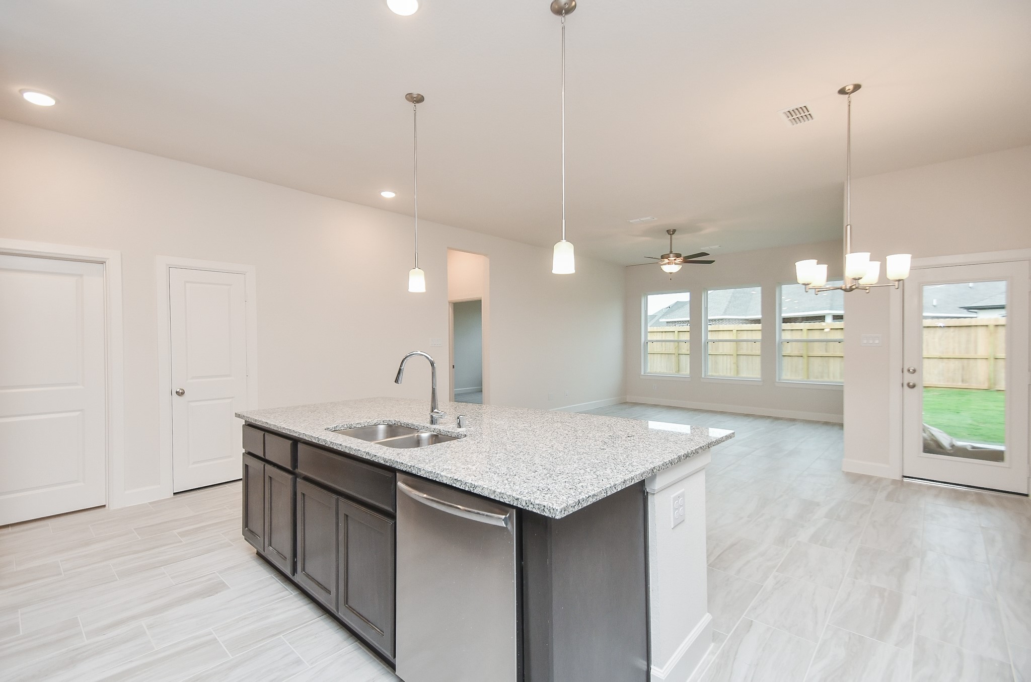 146 Amaranth Way Richmond, TX 77406 - Photo 6 of 18 a kitchen with a sink chandelier and wooden floor