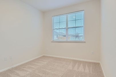 709 Iron Brg Road Georgetown, TX 78626 - Photo 9 of 11 A well-lit room with soft carpeting and a window offering natural light.