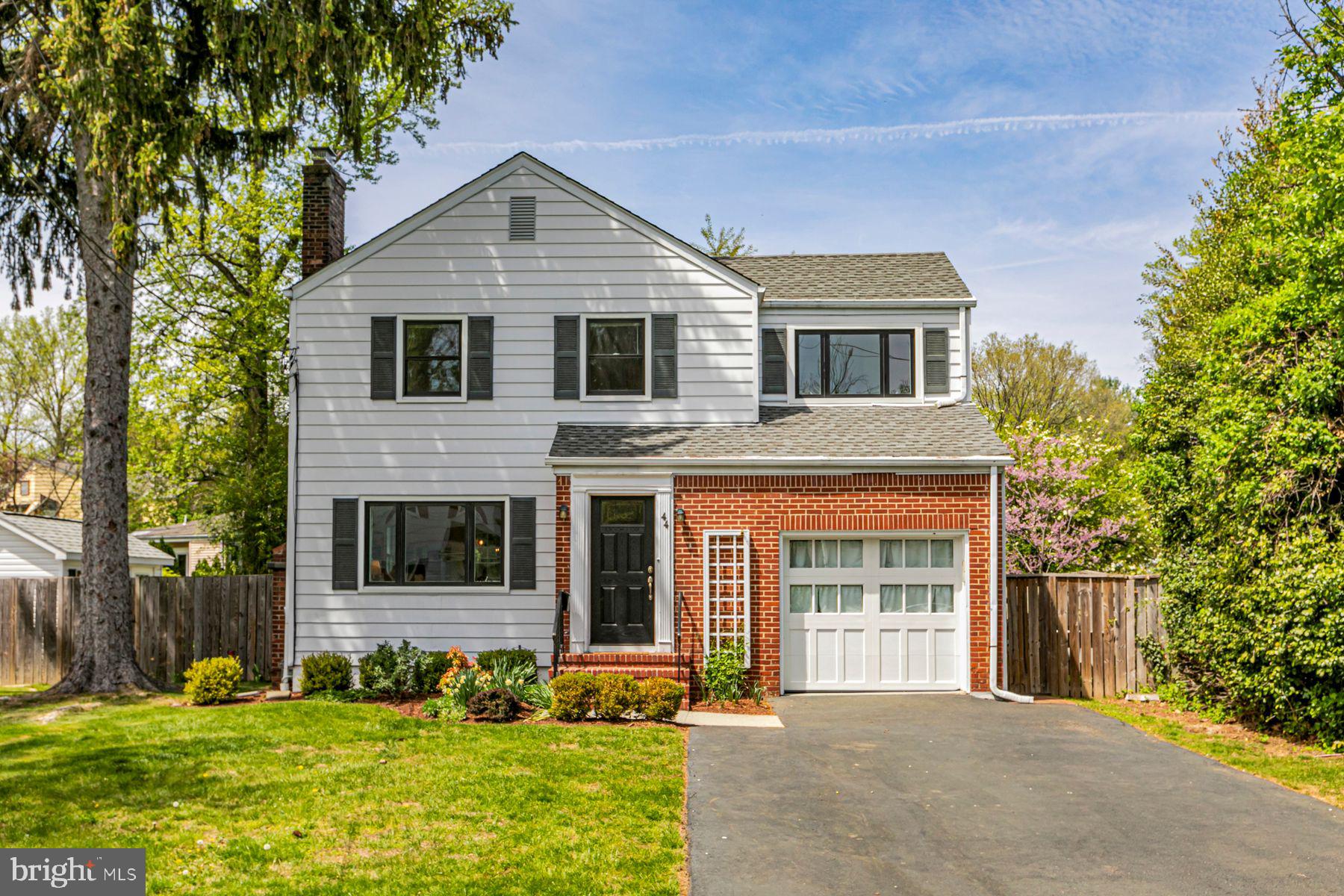 a front view of a house with a yard and trees