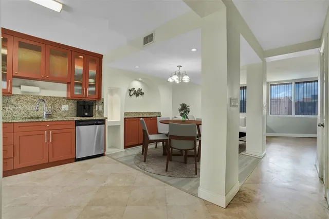a open kitchen with granite countertop a refrigerator a stove top oven a sink and dishwasher