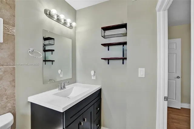 a bathroom with a sink a light fixture and a mirror