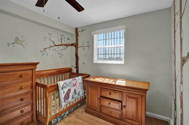 an empty room with wooden floor closet and windows
