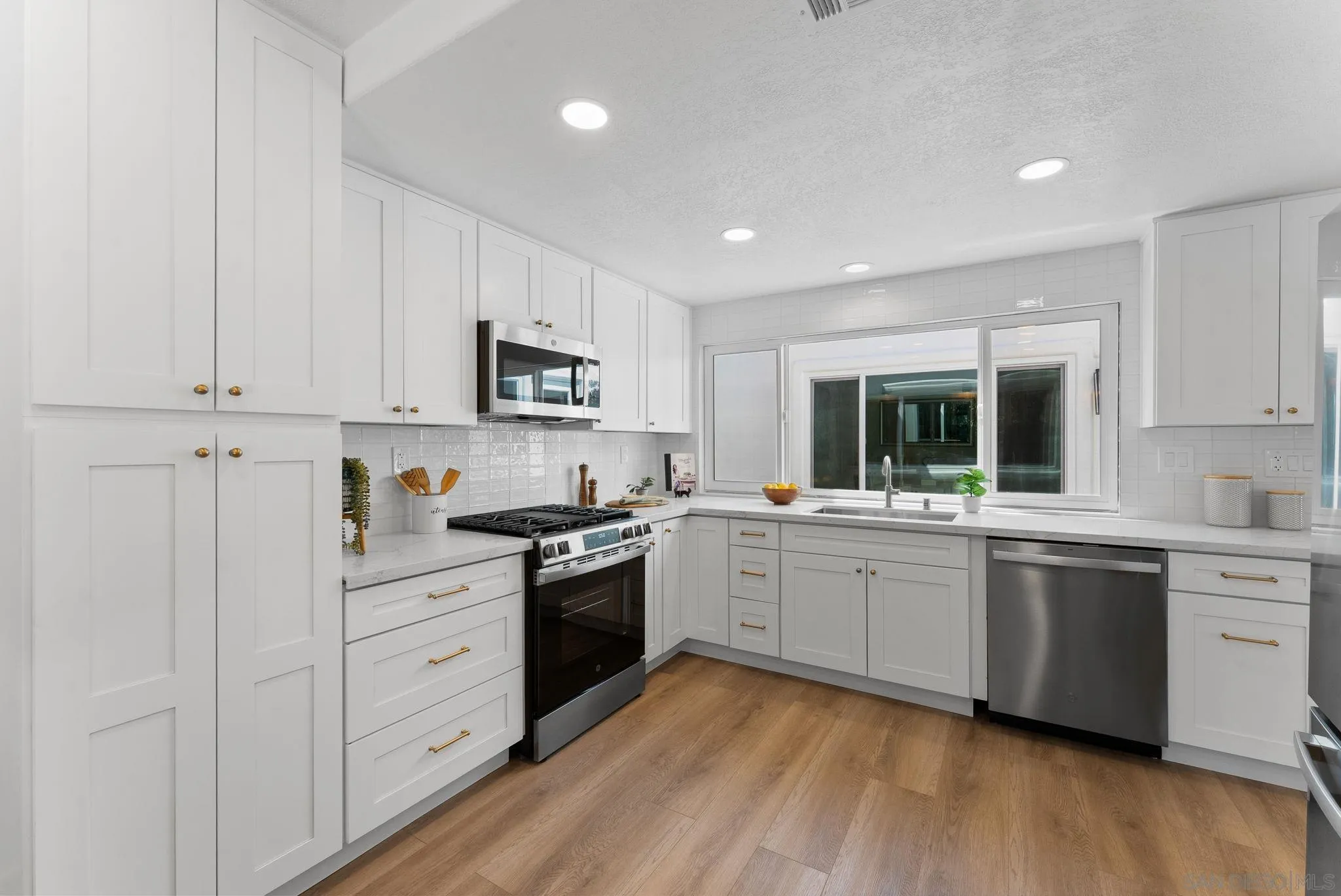 4714 Athos Way Oceanside, CA 92056 - Photo 15 of 34 a kitchen with cabinets oven and a sink
