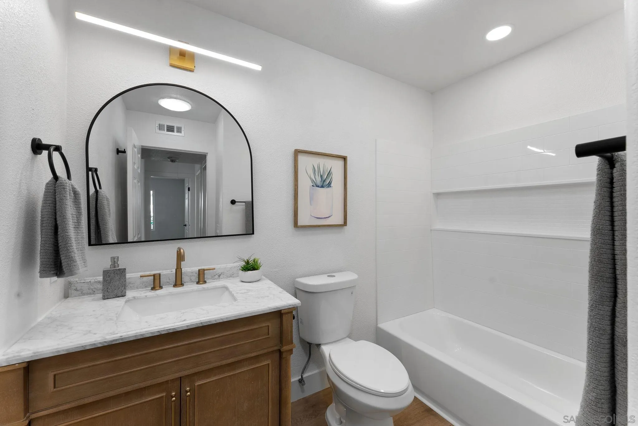 4714 Athos Way Oceanside, CA 92056 - Photo 21 of 34 a bathroom with a granite countertop toilet a sink and a mirror