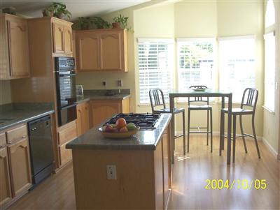 48 Yosemite Road, Unit 48 San Rafael, CA 94903 - Photo 3 of 8 a kitchen with stainless steel appliances granite countertop a stove top oven a sink a dining table and chairs