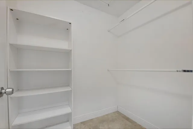 a view of walk in closet with empty racks