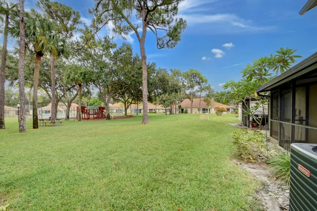 an aerial view of residential houses with outdoor space and trees