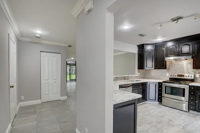 a kitchen with kitchen island a sink stainless steel appliances and cabinets