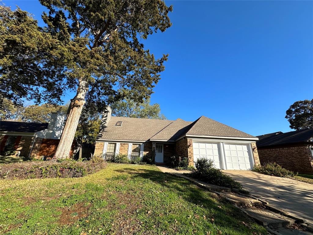 307 Harrington Lane Euless, TX 76039 - Photo 1 of 20 Single story home featuring a chimney, concrete driveway, a shingled roof, a front yard, and brick siding