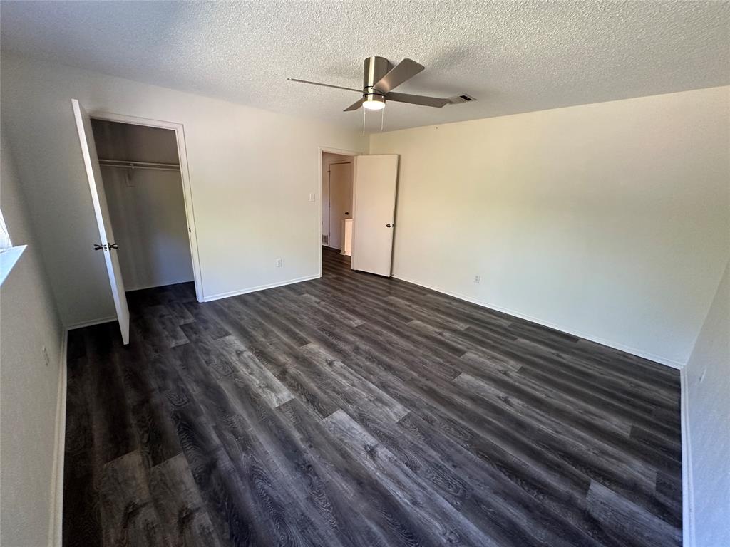307 Harrington Lane Euless, TX 76039 - Photo 16 of 20 Unfurnished bedroom featuring dark wood finished floors, a ceiling fan, and a textured ceiling