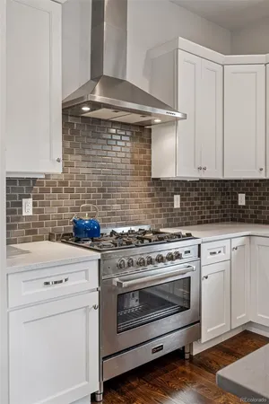 a kitchen with a stove and white cabinets