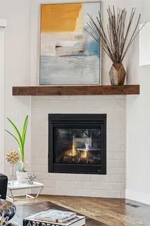 a living room with a fireplace and a potted plant