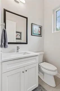 a bathroom with a toilet a sink and mirror