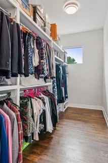 a view of walk in closet with clothes and shoes