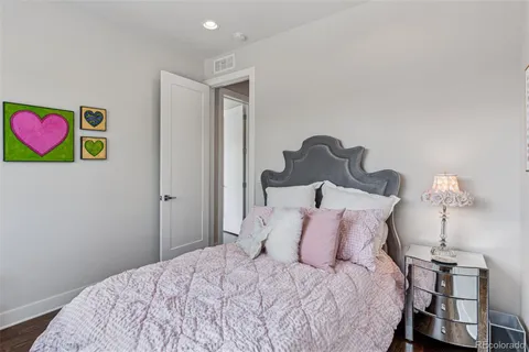 a bedroom with a bed and a painting on the wall