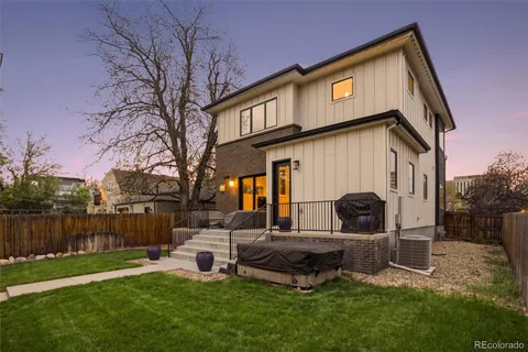 a backyard of a house with table and sofas