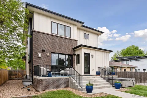 a view of a house with couches and a table and chairs with wooden fence