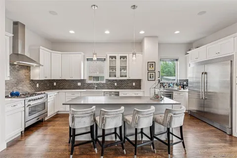 a kitchen with stainless steel appliances granite countertop a table chairs stove microwave and cabinets