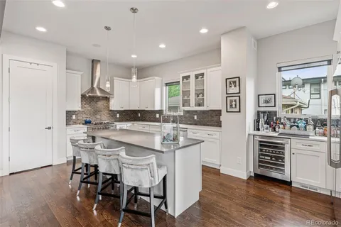 a kitchen with stainless steel appliances kitchen island granite countertop a table chairs sink and cabinets