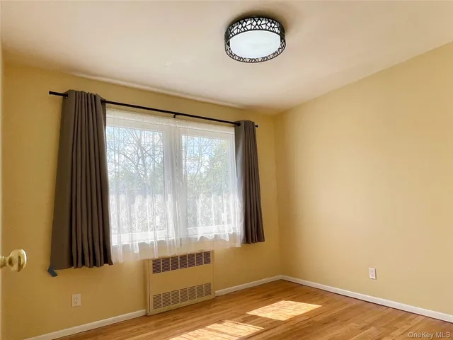 a view of a room with wooden floor and a window