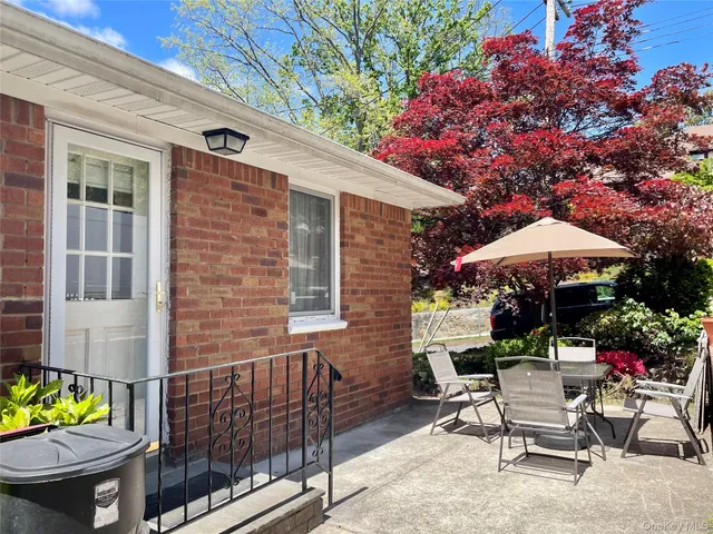 a view of a patio with a table and chairs under an umbrella