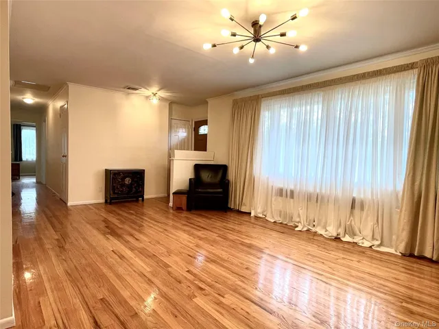 a view of a livingroom with a fireplace a ceiling fan and wooden floor
