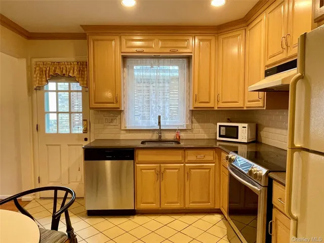 a kitchen with stainless steel appliances granite countertop a stove a sink and a microwave