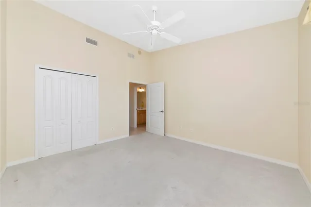 an empty room with a ceiling fan and a window