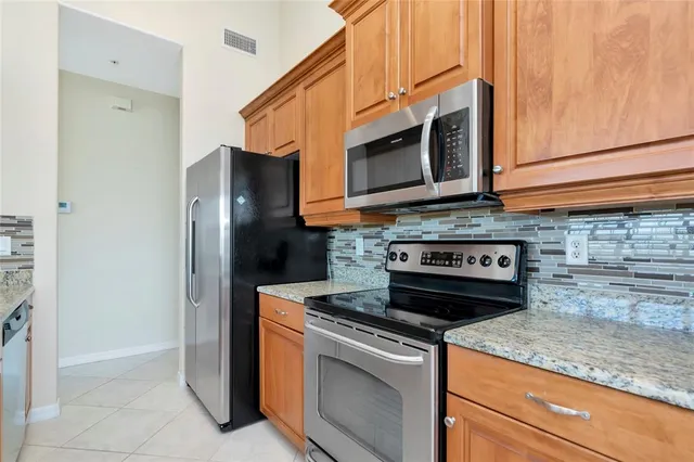 a kitchen with stainless steel appliances granite countertop white cabinets and a stove