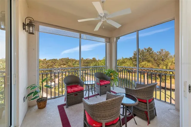 a living room with furniture a chandelier and a floor to ceiling window