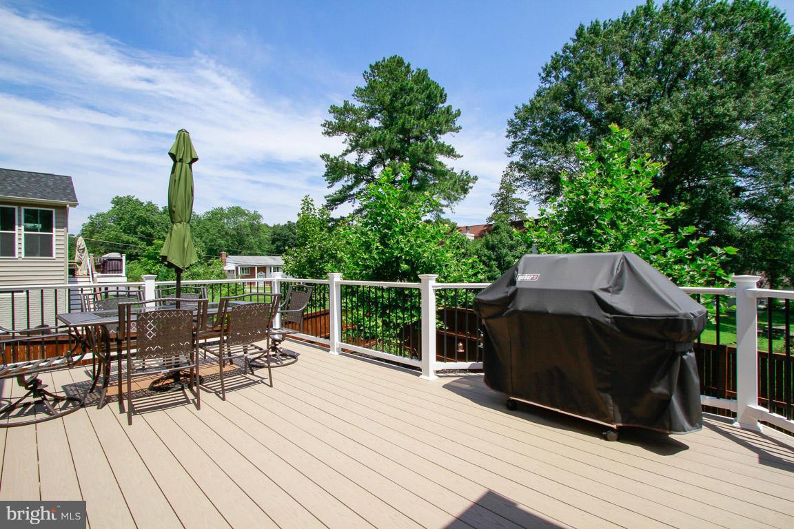 10502 Windlass Run Road Baltimore, MD 21220 - Photo 26 of 26 a view of a roof deck with table and chairs a barbeque with wooden floor and fence