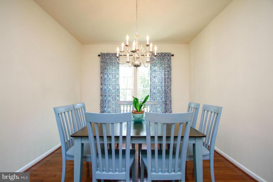 10502 Windlass Run Road Baltimore, MD 21220 - Photo 8 of 26 a view of a dining room with furniture a chandelier and wooden floor