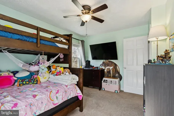 a bedroom with a bed and a flat tv screen on the dresser