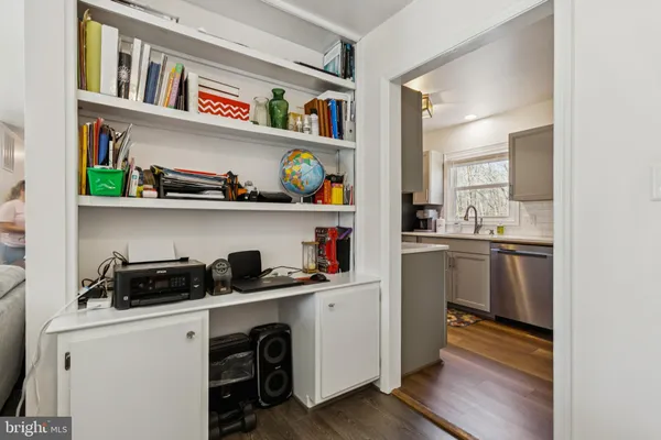 a kitchen with stainless steel appliances granite countertop a stove top oven a sink dishwasher and a refrigerator with wooden floor