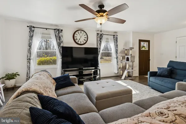 a living room with furniture a flat screen tv and a window